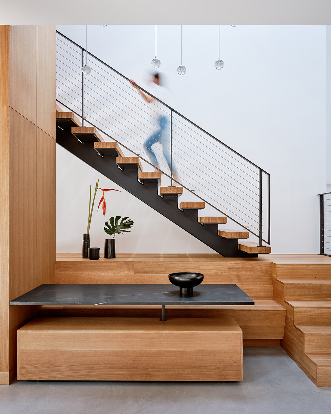 Austin Modern Home Addition stairwell and built-in table with person ascending