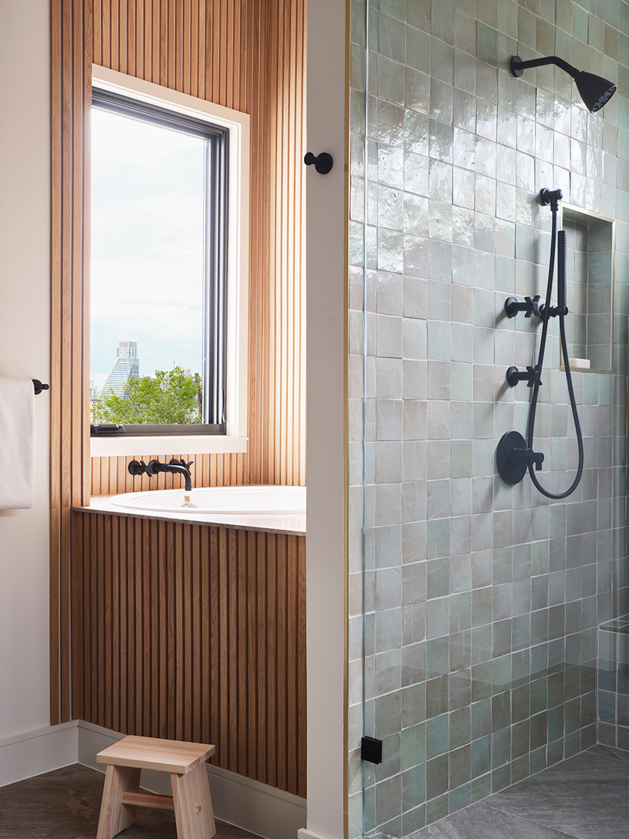 Modern bathroom renovation featuring a wood clad tub and tiled shower.