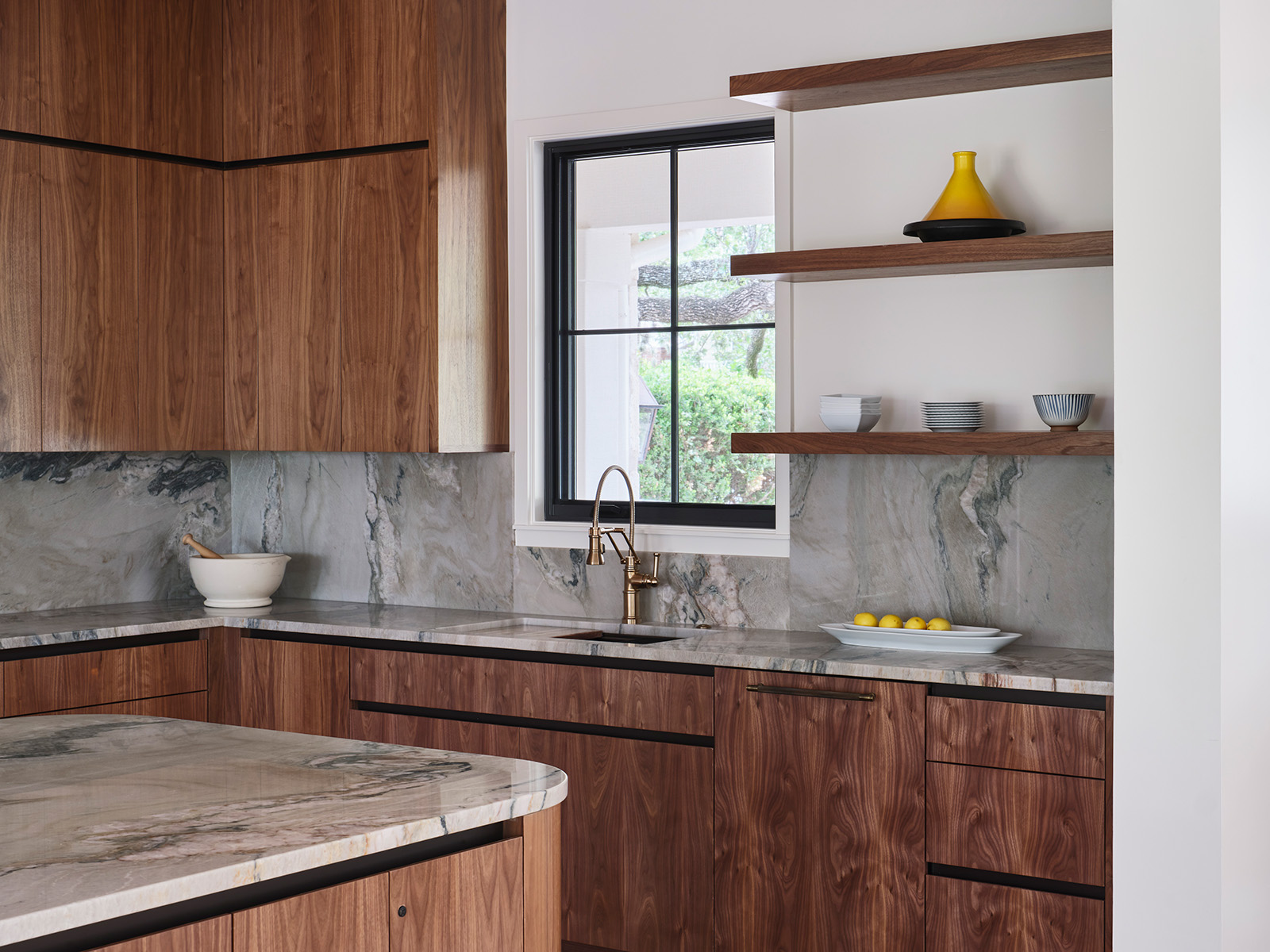 Renovated and expanded kitchen with mahogany cabinets and a dynamic-patterned stone backsplash.