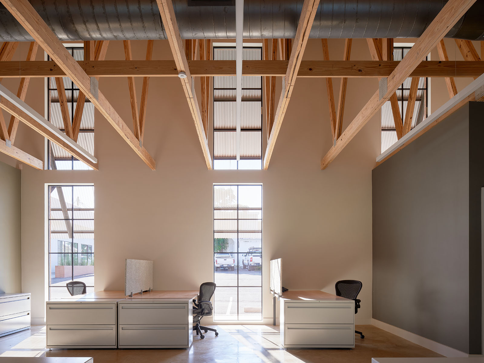 Interior office space with desks and exposed wood beams of Texas Construction Company office new construction by Chioco design architecture