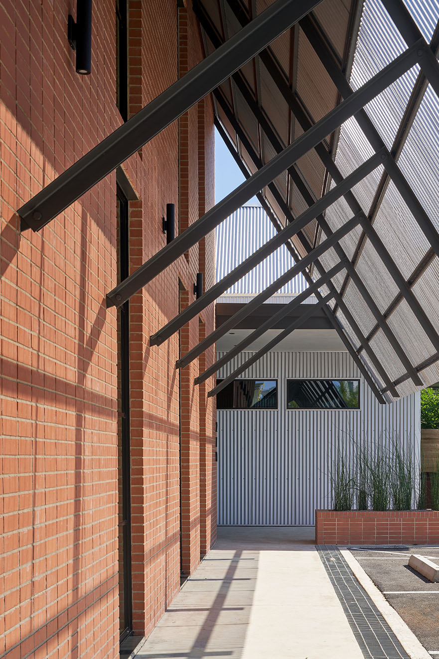 Exterior awning with shadow against brick wall of Texas Construction Company office new construction by Chioco design architecture