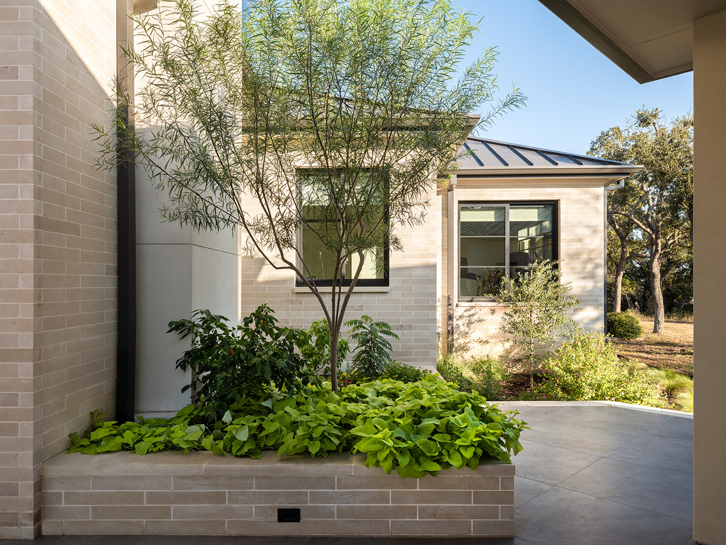 House Renovation & Addition in Austin, TX - Exterior side area with limestone walls.