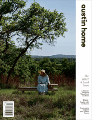 Cover of Austin Home magazine’s Water & Land Issue showing a woman in a light blue dress and sun hat sitting on a bench under a tree with Texas Hill Country in the background, featuring the Reed Park new construction project.