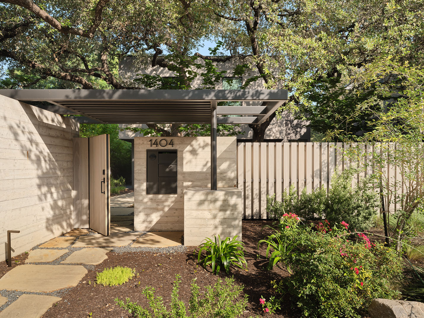 Modern concrete and wood entry gate with horizontal pergola at the 5th Street House Addition in Austin, TX, designed by FAB Architecture and built by Texas Construction Company.
