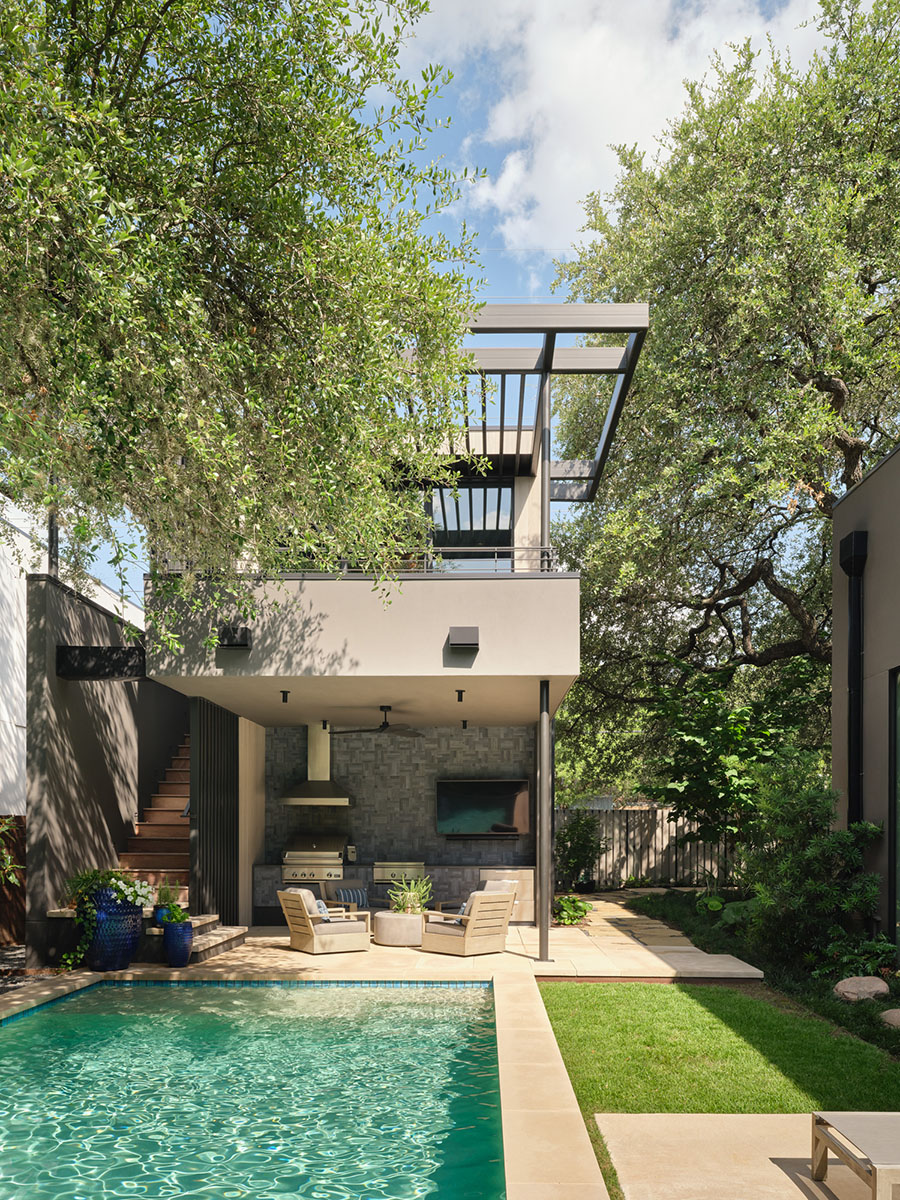 Covered outdoor living area with pool, lounge seating, and built-in grill at the 5th Street House Addition in Austin, TX, designed by FAB Architecture and built by Texas Construction Company.