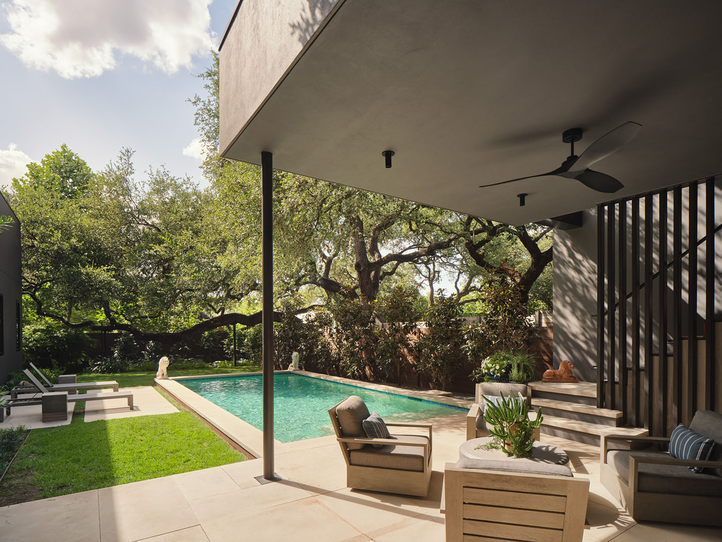 Covered outdoor lounge with ceiling fan and poolside seating at the 5th Street House Addition in Austin, TX, built by Texas Construction Company and designed by FAB Architecture.