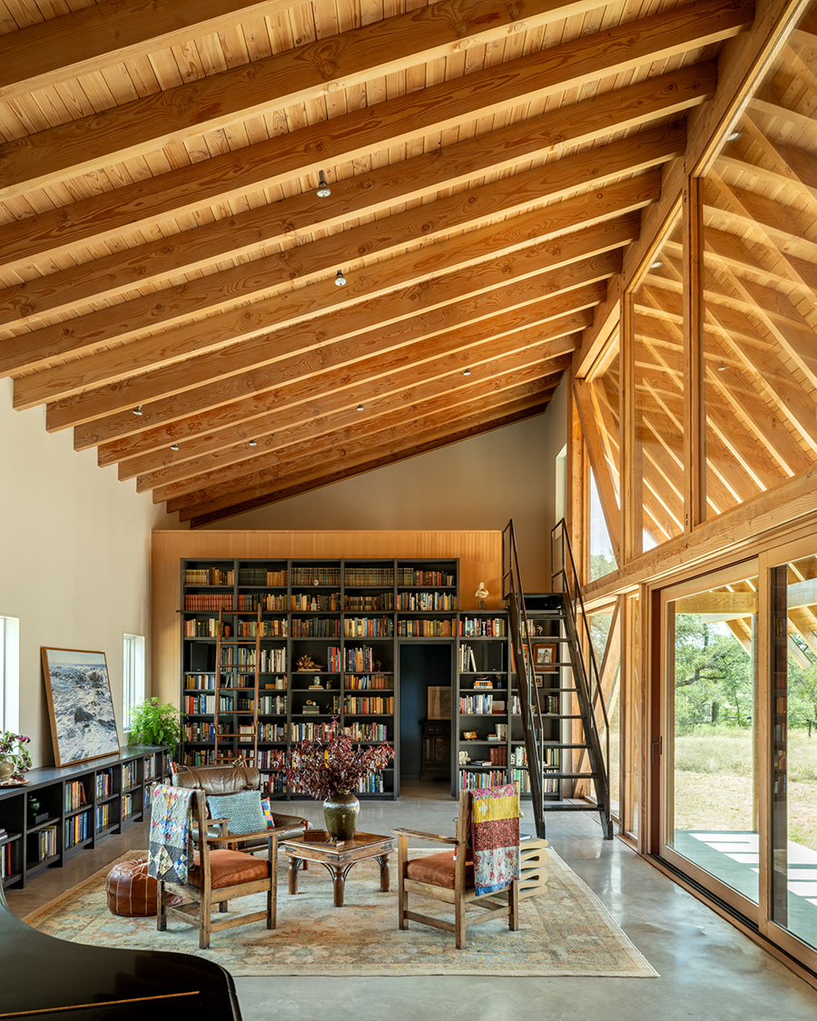 Library and reading space in a custom-built Austin home featuring floor-to-ceiling bookshelves, vaulted wood ceiling, and natural light by Texas Construction Company
