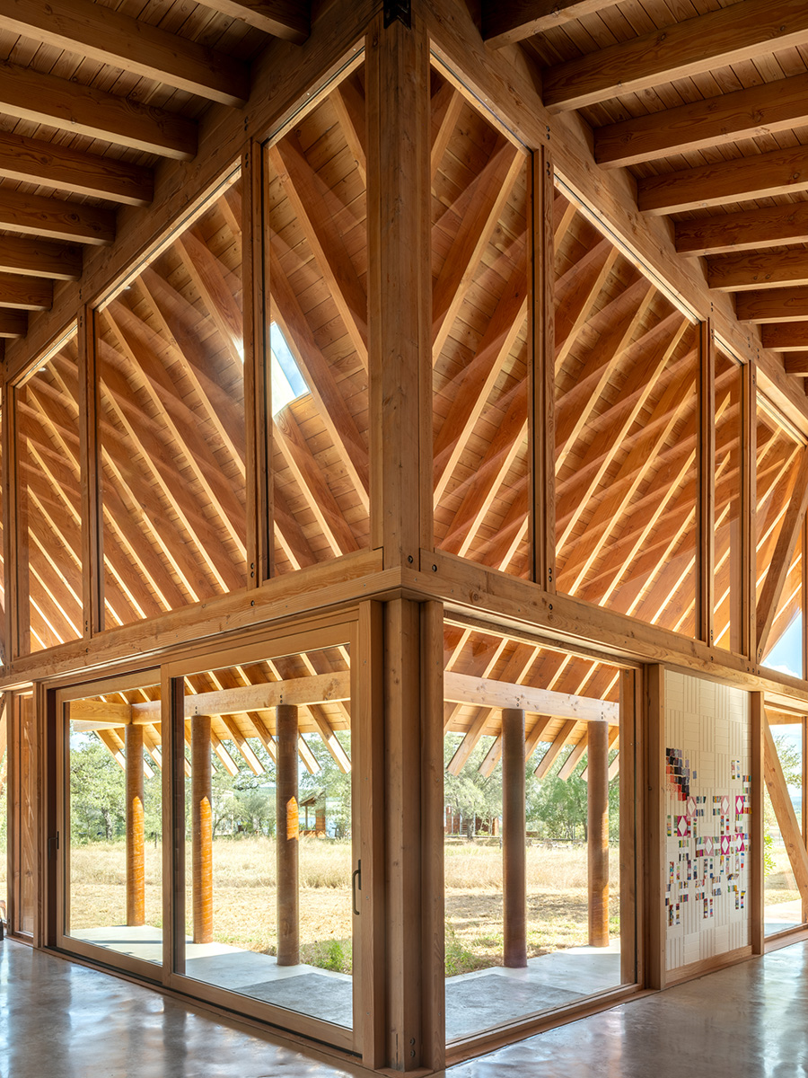 Interior view of custom home in Austin, Texas with floor-to-ceiling glass walls and exposed wood framing built by Texas Construction Company