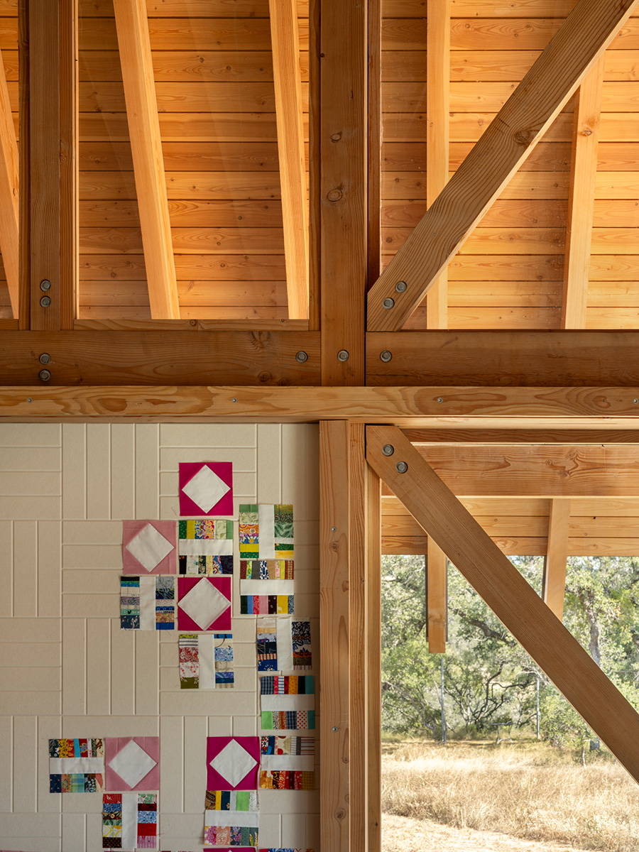 Close-up of exposed timber framing and artistic quilt pattern wall in a custom-built Austin home by Texas Construction Company